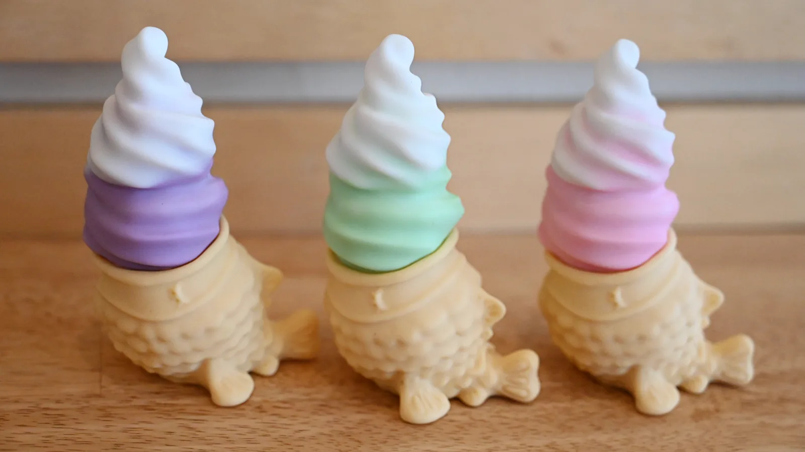Three Chai-brators in a row on a wooden table: ube purple, matcha green and strawberry pink